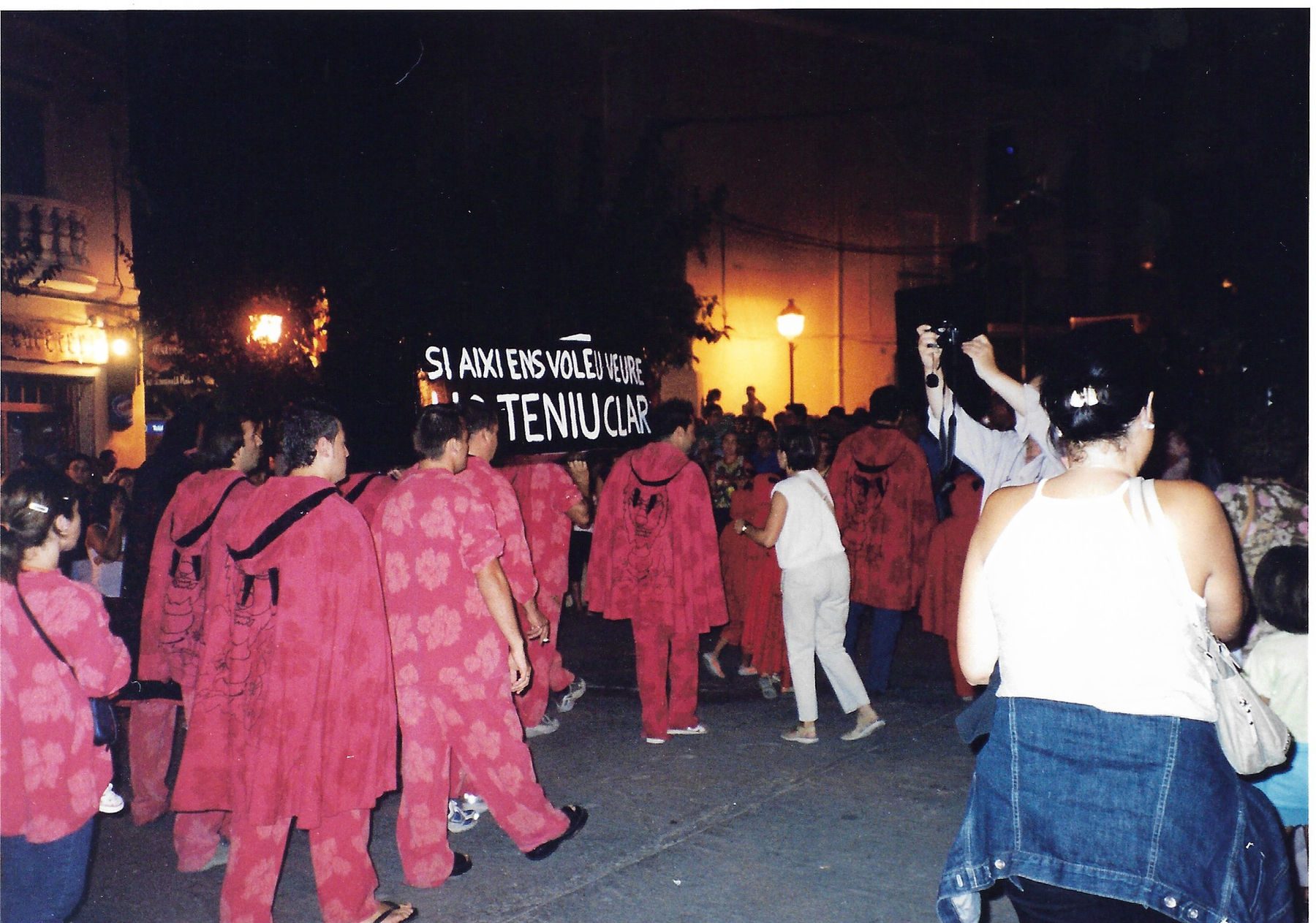 La colla desfila de nit darrere una pancarta de protesta: «Si aquí ens voleu veure, ho teniu clar»